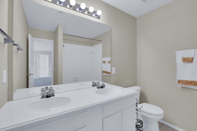 Bathroom with toilet, tile patterned flooring, double vanity, and a sink | Image 31