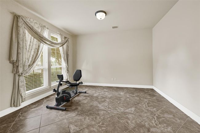 Just off the entry, a flexible space with oversized windows offers the ideal setting for a formal sitting room or office. | Image 7