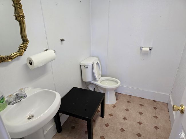 Bathroom with baseboards, toilet, tile patterned floors, and a sink | Image 14