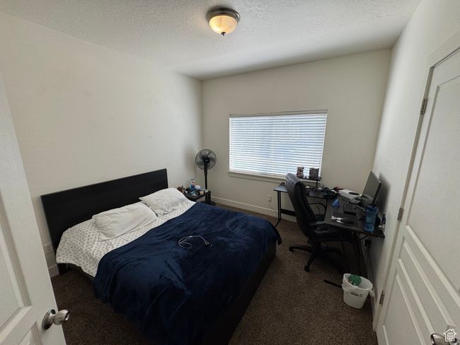 Bedroom with a textured ceiling and carpet | Image 11