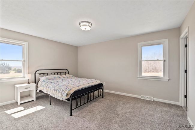 Bedroom featuring carpet, baseboards, and visible vents | Image 17