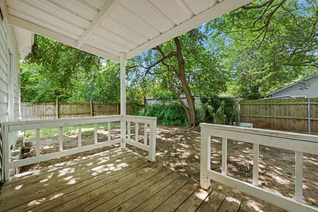 Wooden terrace with a fenced backyard and view of scattered trees | Image 27
