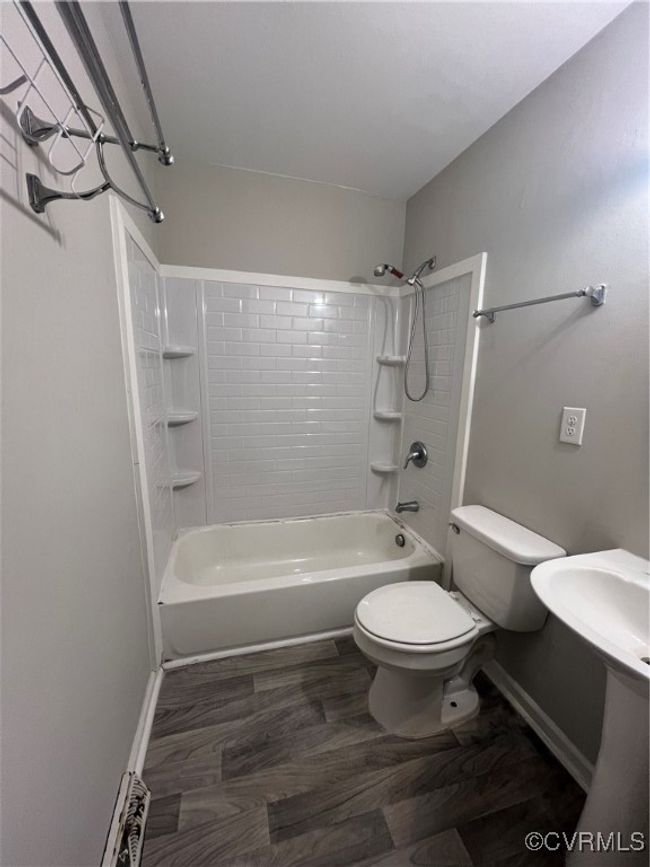 Full bath with wood finished floors, bathtub / shower combination, toilet, and baseboards | Image 10