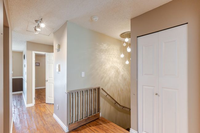 Stairs featuring a textured ceiling, baseboards, and wood finished floors | Image 27