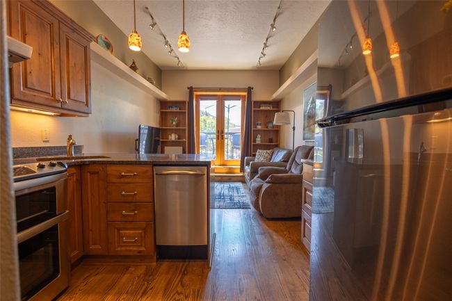 Kitchen featuring stove, freestanding refrigerator, french doors, track lighting, and brown cabinets | Image 5