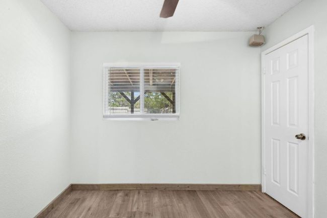 Unfurnished bedroom with light wood-style floors, a textured ceiling, and a ceiling fan | Image 22