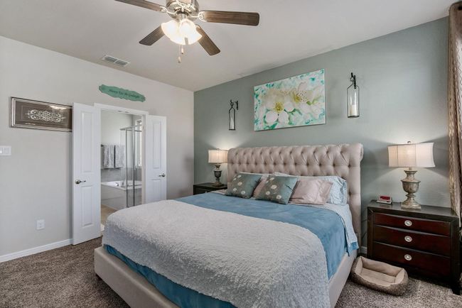 Bedroom featuring carpet flooring, baseboards, a ceiling fan, and ensuite bath | Image 11