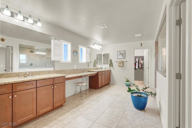 Bathroom with double vanity, a walk in shower, and tile patterned floors | Image 34
