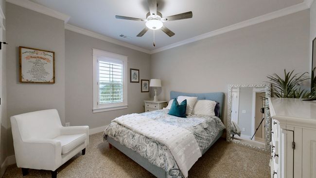 One of the upstairs bedrooms featuring plush carpet, crown molding, and a large window that fills the room with natural light | Image 42