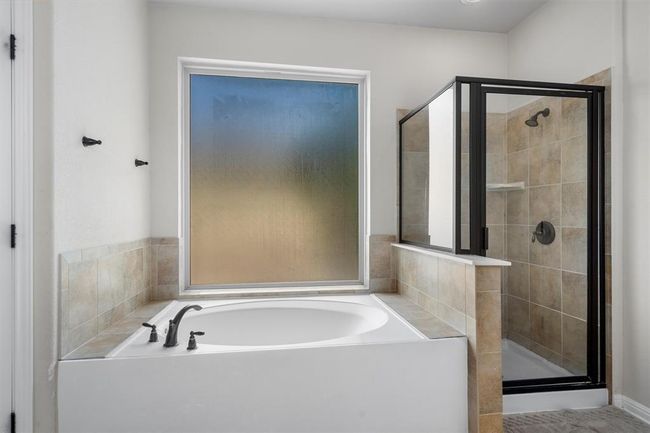 Bathroom featuring a stall shower and a bath | Image 24