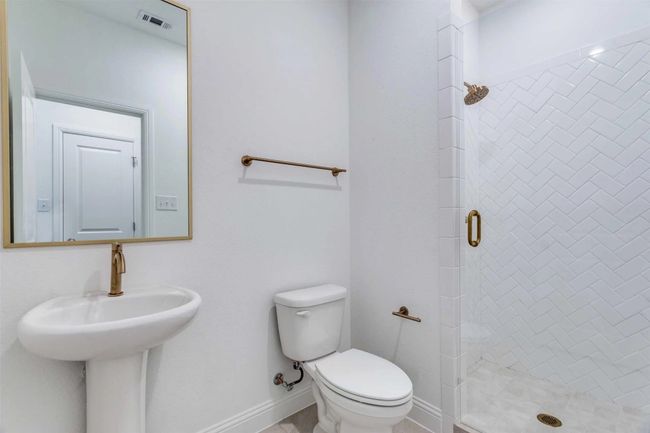 Bathroom featuring toilet and a shower with shower door | Image 14