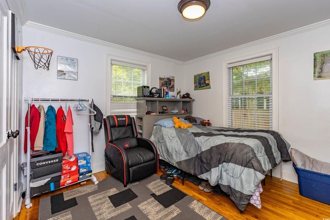 Bedroom featuring crown molding, wood finished floors, and multiple windows | Image 10