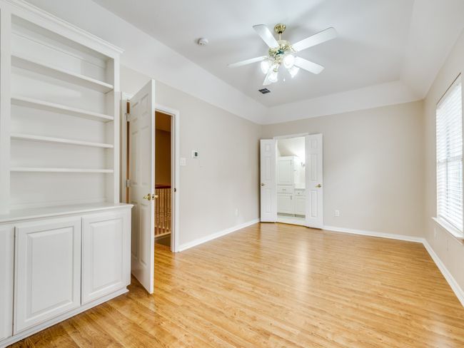 The upstairs room with full bath and walk in closet. laminate floors, and custom built in could be perfect for a private office, a guest suite or even a game room. The listing calls it bedroom four. | Image 23