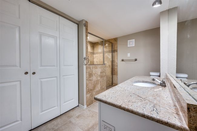 Bathroom featuring a tile shower, vanity, a closet, and tile patterned flooring | Image 8