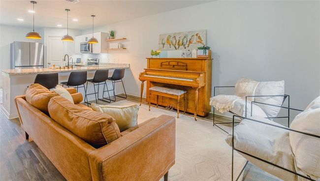 The comfortable living room opens to the kitchen and dining room for ease of entertaining. The lighting is controllable by voice, switch or app. | Image 5