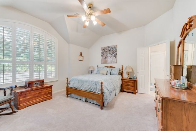 Bedroom featuring vaulted ceiling, light colored carpet, and ceiling fan | Image 22