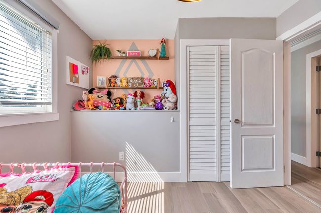 Bedroom featuring light wood-style floors, a closet, and multiple windows | Image 23
