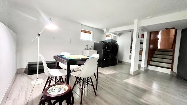 Dining space featuring wood finished floors, washer / clothes dryer, stairs, and baseboards | Image 20