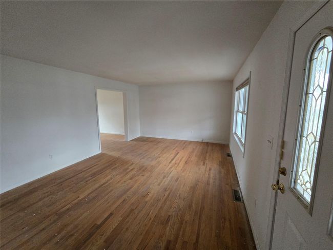 Spare room with wood finished floors and baseboards | Image 6