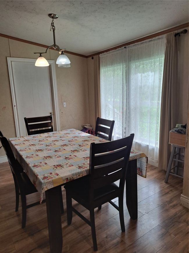 Dining area with wood finished floors, crown molding, and a textured ceiling | Image 7