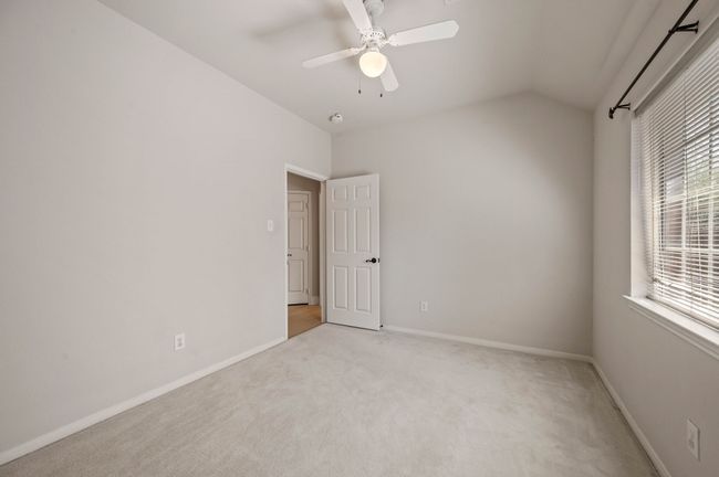 Spare room with light carpet, baseboards, vaulted ceiling, and ceiling fan | Image 32