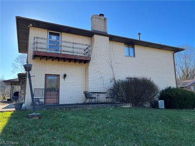 Rear view of house featuring a lawn, a balcony, and central AC | Image 3