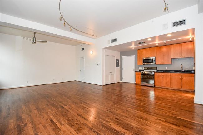 Spacious open-concept kitchen and living area with seamless flow—perfect for entertaining. The kitchen features sleek finishes, ample storage, and a breakfast bar, all overlooking the bright, inviting living space with downtown views. | Image 14