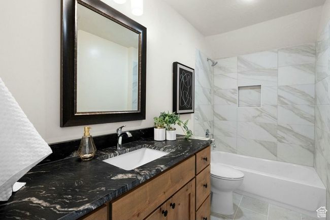 Bathroom featuring tile patterned flooring, toilet, vanity, and shower combination | Image 31