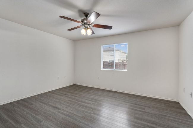 Spare room featuring dark wood-style floors, ceiling fan, and baseboards | Image 11