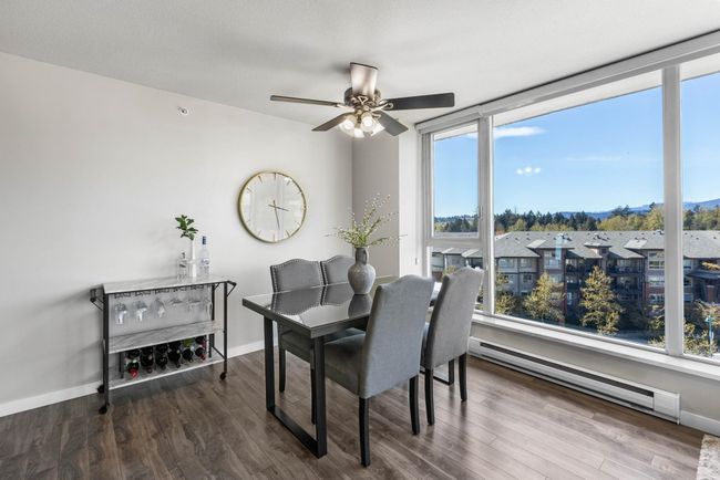 Dining room featuring a baseboard heating unit, baseboards, a ceiling fan, and wood finished floors | Image 9