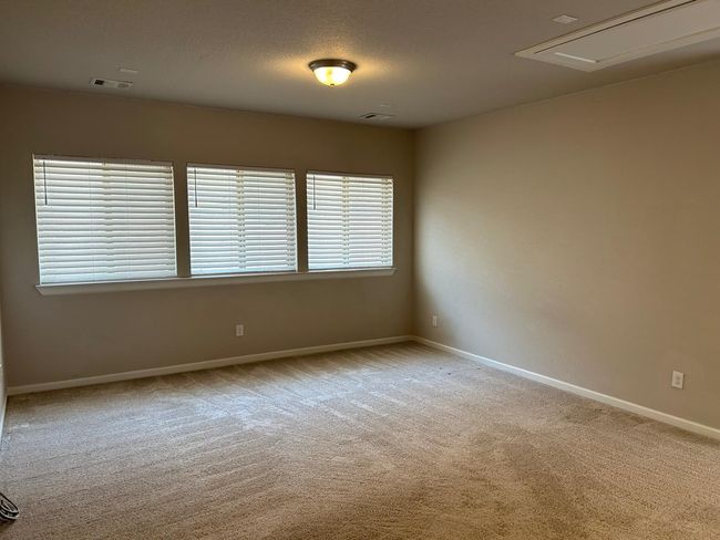 Carpeted spare room featuring baseboards and attic access | Image 22
