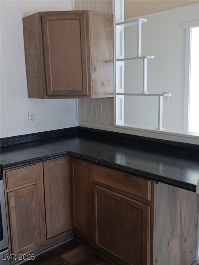 Kitchen featuring dark countertops, brown cabinets, and dark wood finished floors | Image 17