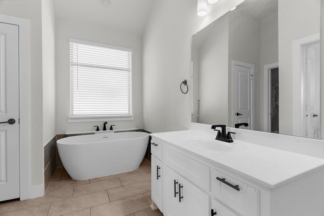 Bathroom with vanity, a soaking tub, and tile patterned flooring | Image 29