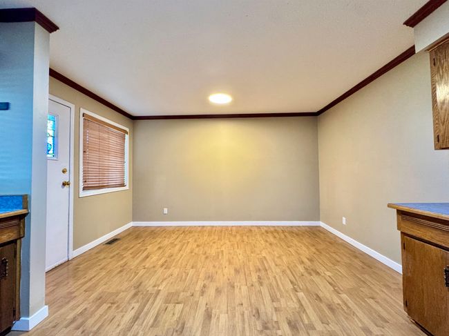 Unfurnished living room with crown molding and light wood-type flooring | Image 6