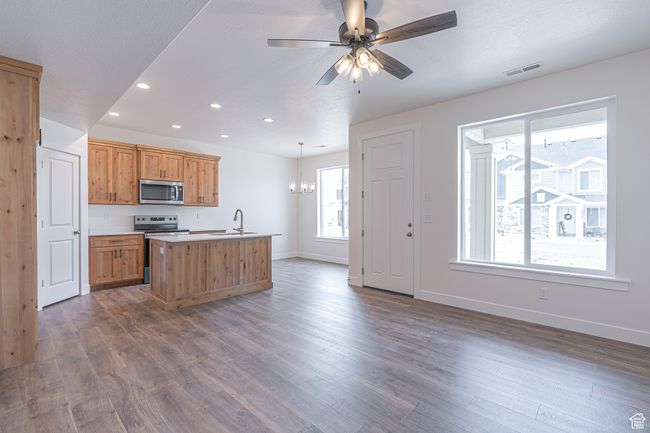 Kitchen with appliances with stainless steel finishes, recessed lighting, a kitchen island with sink, a chandelier, and dark wood-style flooring | Image 4
