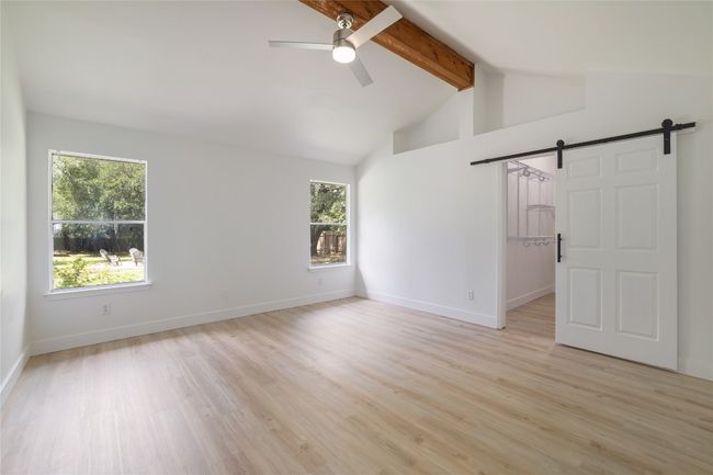 Primary bedroom features a gorgeous wood beam and vaulted ceilings. | Image 17