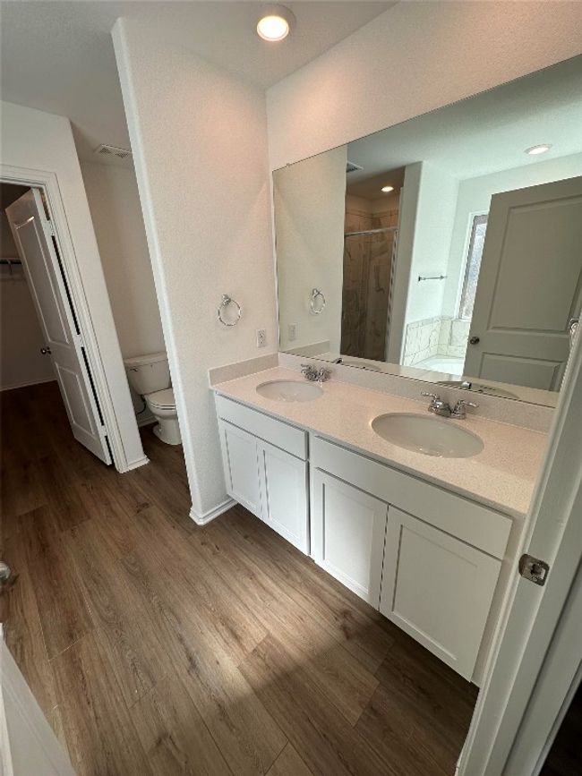 Bathroom featuring double vanity, toilet, a sink, and a stall shower | Image 15