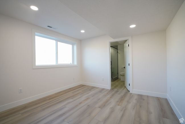 Unfurnished bedroom with light wood-style floors, recessed lighting, and baseboards | Image 25