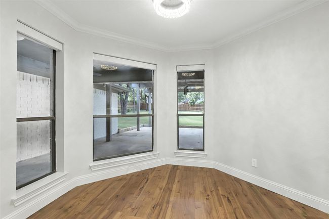 Spare room featuring wood finished floors and crown molding | Image 17