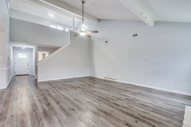 Unfurnished living room with beam ceiling, ceiling fan, light wood-type flooring, and high vaulted ceiling | Image 10