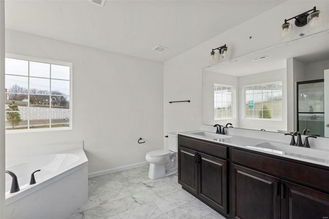 Bathroom featuring vanity, toilet, and a bathing tub | Image 6