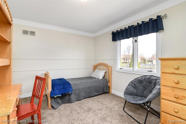 Other bedroom is drenched in natural light and features neutral decor. | Image 10