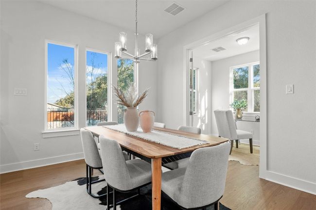 Dining space featuring visible vents, wood finished floors, baseboards, and a notable chandelier | Image 9