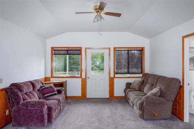 Living room featuring lofted ceiling, carpet flooring, and a ceiling fan | Image 85