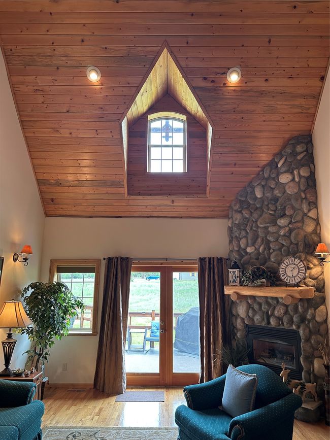 Breathtaking Custom Window Framed in Tongue & Groove Ceilings, Custom Rock Fireplace. | Image 4