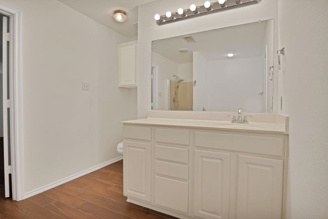 Bathroom with wood finished floors, vanity, and a shower | Image 13