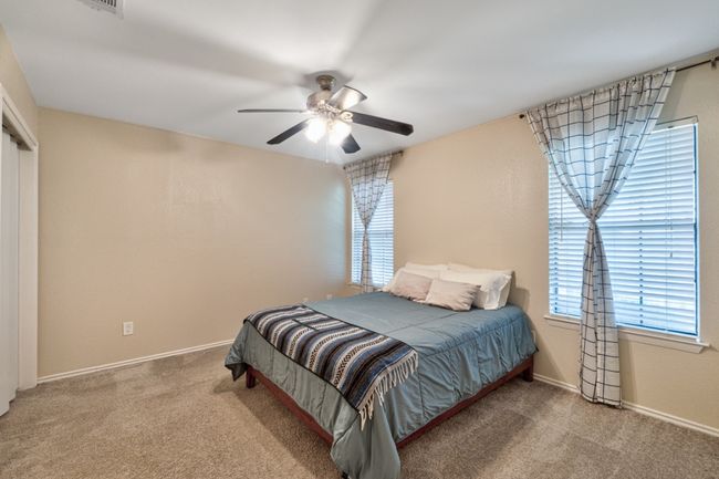 Primary bedroom features ensuite, ceiling fan, and plenty of storage space with two closets. | Image 14
