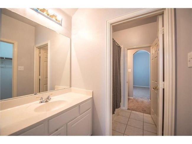 Bathroom with vanity, tile patterned flooring, and a shower with shower curtain | Image 19