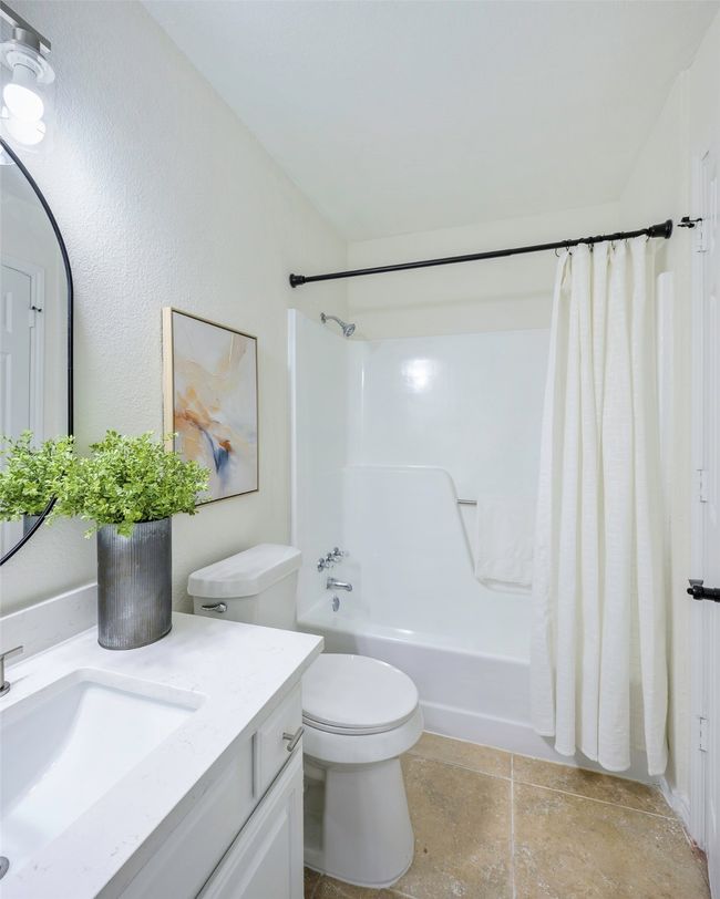 Bathroom featuring vanity, toilet, and shower / tub combo with curtain | Image 7