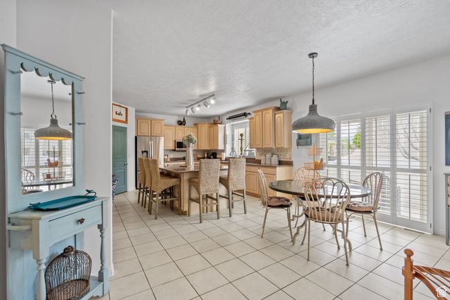 Dining area with a textured ceiling and light tile patterned flooring | Image 17